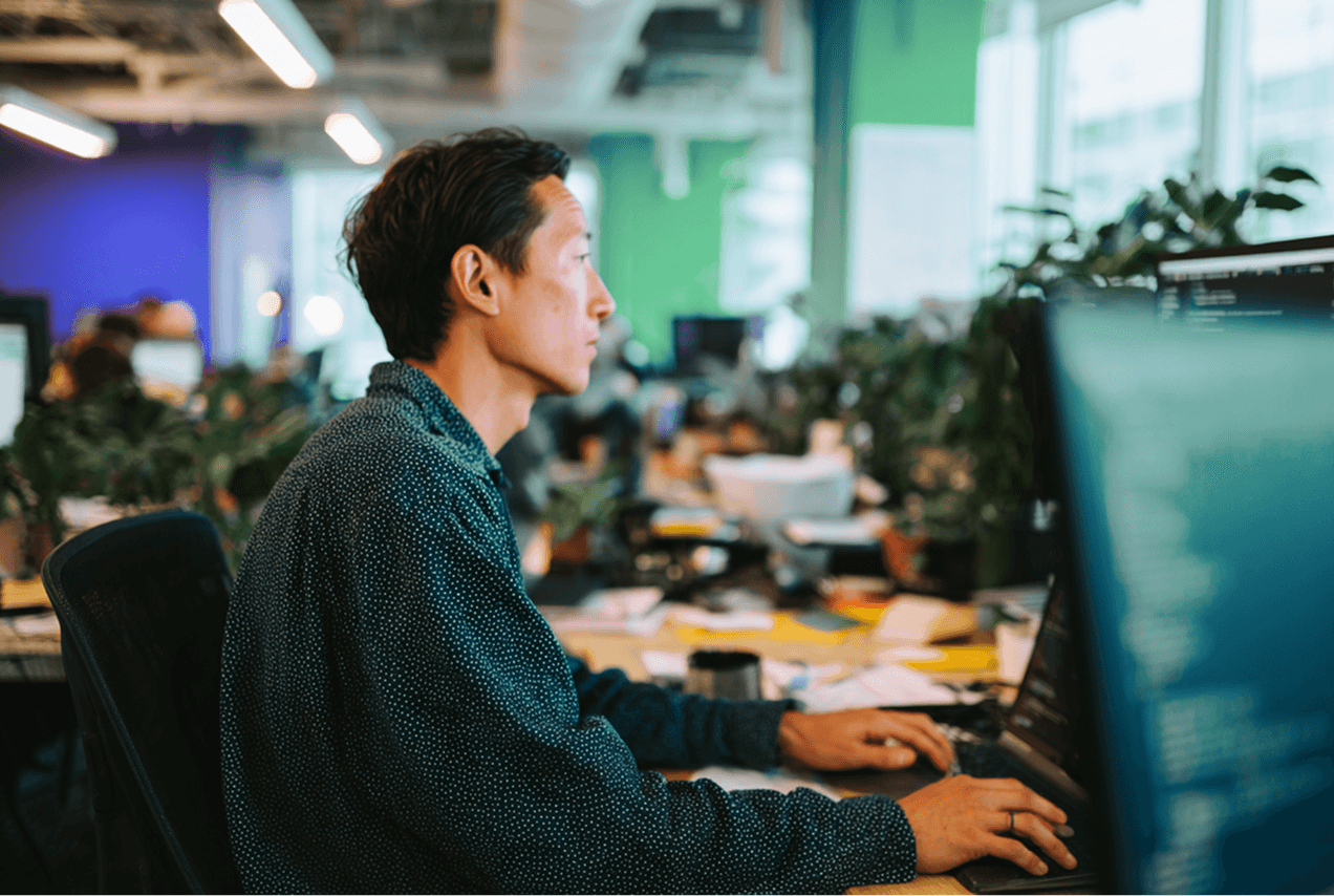 An image depicting the building of software, a man on a computer.